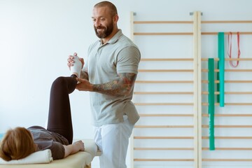 Injured patient and professional physiotherapist doing muscle stretching exercises