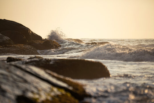 Waves on sandy ocean beach under a beautiful sunset in Sri Lanka island.