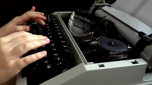 The girl is typing on a retro typewriter.