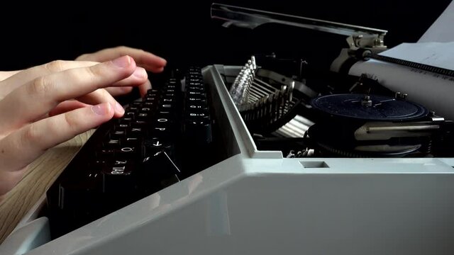 The girl is typing on a retro typewriter.
