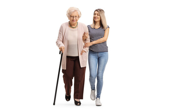 Full Length Portrait Of A Kind Young Woman Helping An Elderly Woman Walking With A Cane