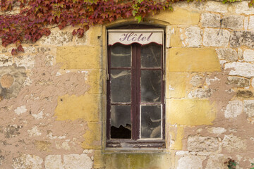 Fototapeta na wymiar Hotel sign over an abandoned derelict window