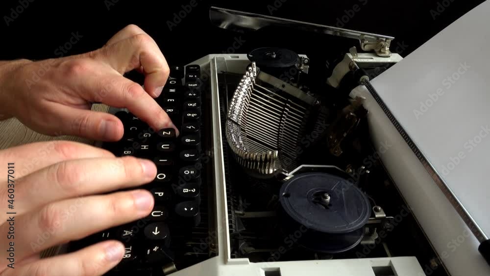 Poster the man is typing on a retro typewriter.