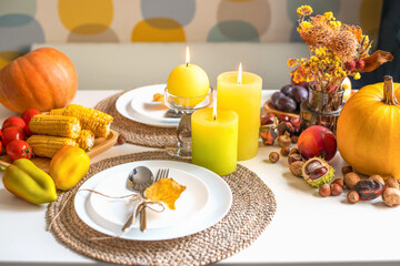 Thanksgiving dinner. Halloween dinner. Festive table with pumpkin, autumn leaves and seasonal autumn decor. Table setting in