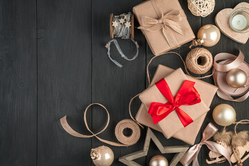 Fototapeta na wymiar Packed gifts with red and beige ribbons on a black background. Merry Christmas and Happy New Year.
