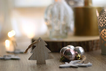 Wooden Christmas ornaments, lit candles and vase with gypsophila flowers. Hygge at home. Selective focus.