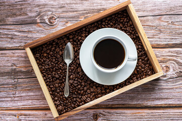 Photography of black coffee, coffe beans, spoon, wooden box, wooden background