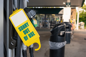 Sorry Out of Use sign on a pump in England as fuel shortage hits the country. People waiting in...