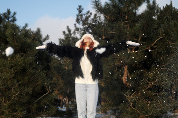  woman in hat joying winter forest. Winter holidays 2021 concept