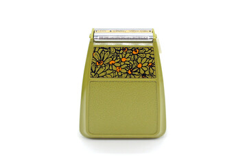 Vintage green electric shaver, isolated on white background, close-up