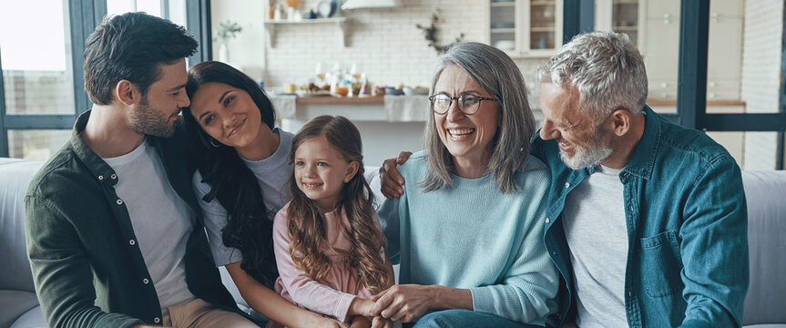 Happy family spending time together and smiling while sitting on the sofa at home
