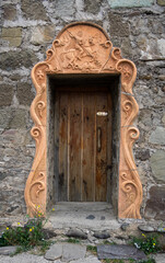 Old wooden door in a monastery with a bas-relief of St. George