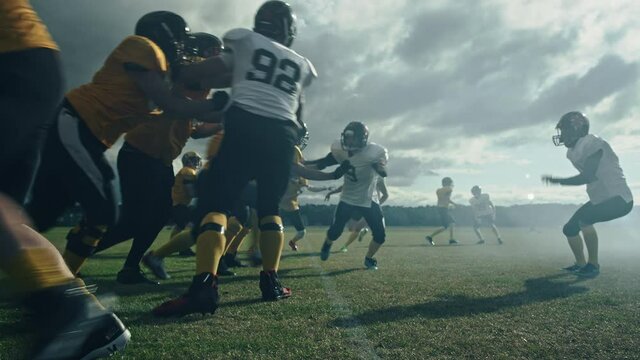 American Football Field: Two Professional Teams Clash, Trying to Score Touchdown Points. Defense and Offense Brutally Compete for the Ball, Tackle Each other. Dramatic Cinematic Slow Motion Shot