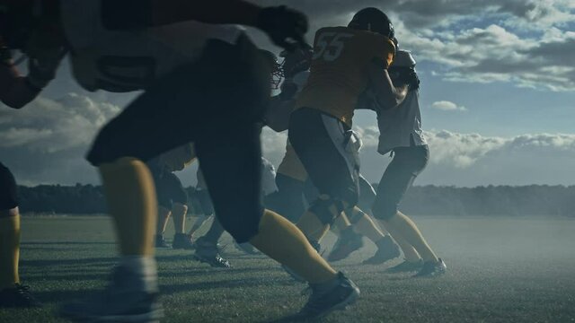 American Football Field Two Teams Compete: Players Pass and Run to Score Touchdown Points. Professional Athletes Compete for the Ball, Tackle, Fight for Championship Victory. Cinematic Slow Motion