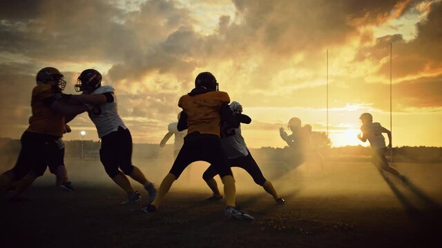 American Football Field Two Teams Play: Successful Player Running to Score Touchdown Points. Professional Athletes Compete for the Ball, Tackle, Fight for Victory. Dramatic Golden Hour, Slow Motion