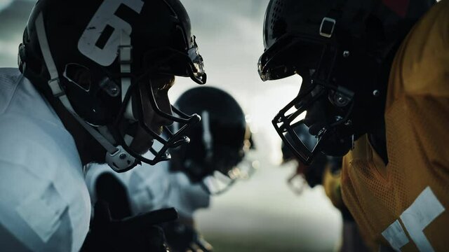American Football Game Start Teams Ready: Close-up Portrait of Two Professional Players, Aggressive Face-off. Competitive Warriors Full of Brutal Energy, Power, Skill. Dramatic Stare. Cinematic Shot