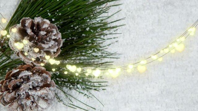 Animation of glowing fairy lights and christmas pinecones decorations