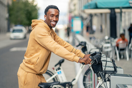 A young man using public bicycles in the undocking