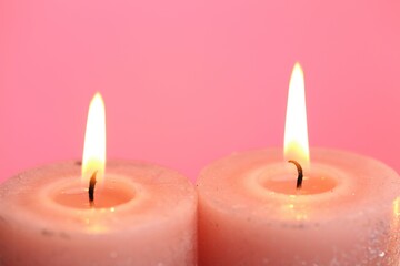Candles set. Burning candles on a pink background. Festive shiny candles. Flame candles close-up.Religion and culture