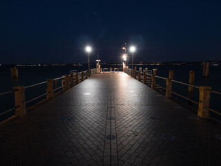 Obraz premium Sirmione Ferry Terminal Jetty on Lake Garda Illuminated at Night