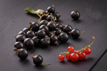 black currant lies on a black wooden surface