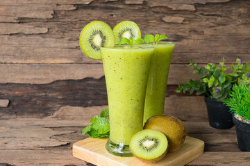 Kiwi yogurt fruit juice smoothie green colorful fruit juice milkshake blend beverage healthy high protein the taste yummy In glass drink episode morning on wood background.