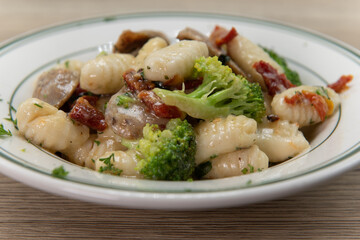 Gnocchi alla barese Italian sausage, broccoli, and tomatoes served in a bowl and drenched in olive oil for a very hearty Italian meal