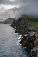 Beautiful aerial view of the Bøsdalafossur waterfall and Trælanípan magnificent landmarks in the Faroe Islands