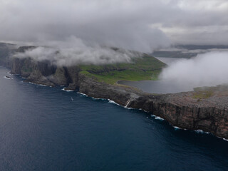 Beautiful aerial view of the Bøsdalafossur waterfall and Trælanípan magnificent landmarks in the Faroe Islands