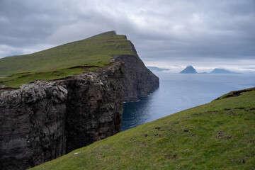 Beautiful aerial view of the Bøsdalafossur waterfall and Trælanípan magnificent landmarks in the Faroe Islands