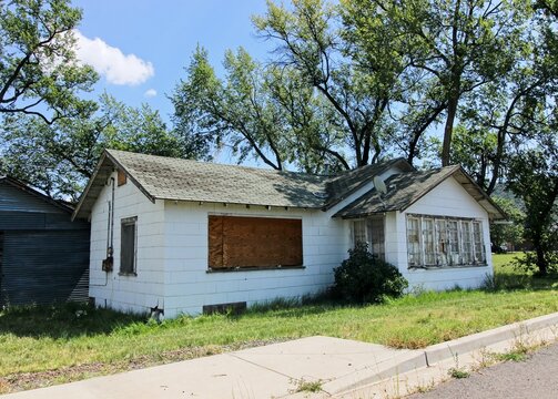 Abandoned One Level Home With Boarded Up Windows