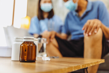 Health visitor and a senior woman during home visit.Worried senior man talking to her general practitioner visiting her at home during virus epidemic.