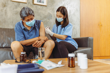 Obraz premium Health visitor and a senior woman during home visit.elderly senior woman and a female nurse show that they are in favor of a vaccination, concept pandemic and coronavirus protection