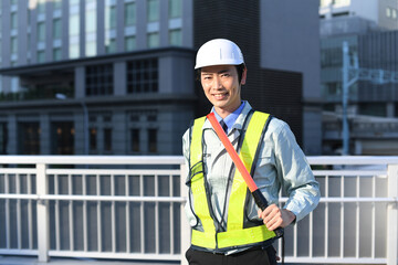 誘導棒を持つ交通誘導をするガードマンの男性