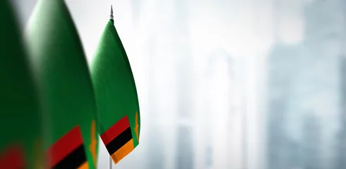 Foto op Aluminium Small flags of Zambia on a blurry background of the city © butenkow