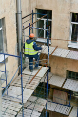 Workers erect scaffolding to repair the facade of a building