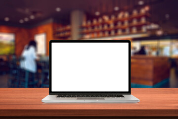 Fototapeta premium Laptop or notebook with blank screen on wood table in in cafe or restaurant background.