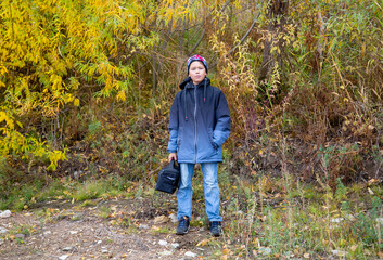 teenager with bag in autumn forest
