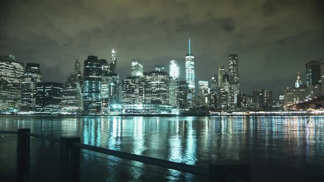 Time lapse in the night of the famous lights of new york, with reflections in the water and sky illuminated by the city