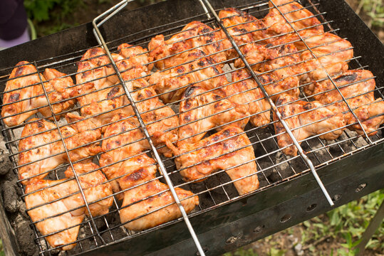 a lot of delicious fried wings on the grill. High quality photo