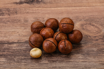 Brown macadamia nut heap over background