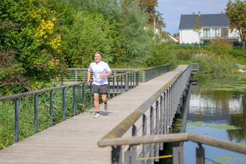 Man jogging across bridge over a river in an urban environment