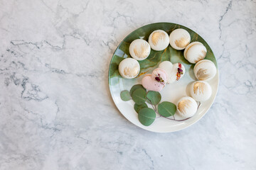 White macaroons are on a plate. Delicious light cookies on a plate on a light background. Bakery. Background for Valentine's Day