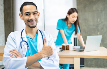 Confident young Asia male doctor in white medical uniform with stethoscope looking at camera and smiling  health hospital.Portrait of a smiling doctor in office.