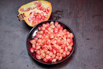 closeup ripe pomegranate fruit and seeds  on wooden background 