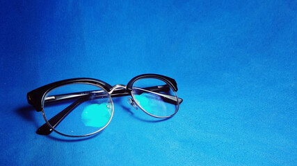 eyeglasses on blue background with space for text