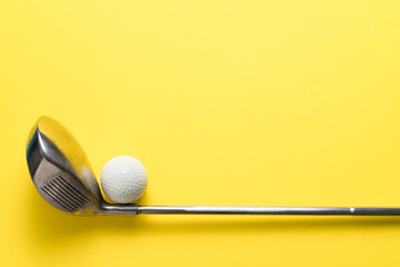 golf ball and golf club on yellow background, sport concept