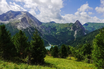 Obraz premium high rocky mountains with a blue lake in the valley while hiking
