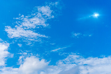 Fototapeta na wymiar 青空と雲と太陽フレアの背景素材_l_03