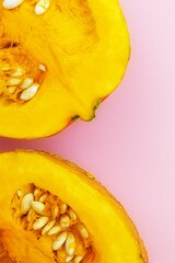 Top view of a pumpkin cut into two equal parts, with pulp and seeds